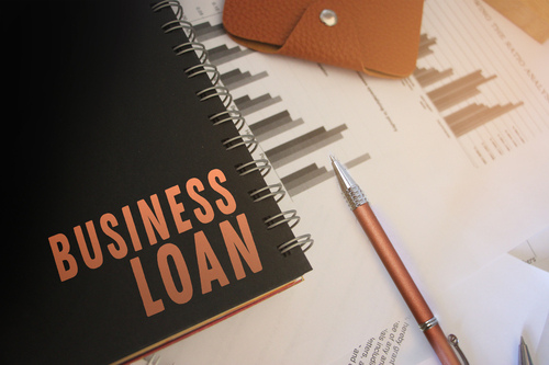 Business loan words on copybooks page, pen, wallet and financial reports. Selective focus. Business sponsorship concept
